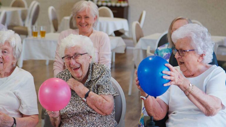 Family member reviewing a care plan with an older adult at an assisted living table